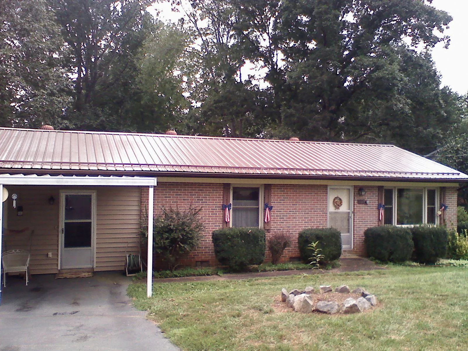 Bronze metal roof and carport on a brick ranch home — Roof Repair work by our crew in Greer